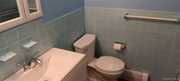 a white toilet sitting next to a bathroom sink
