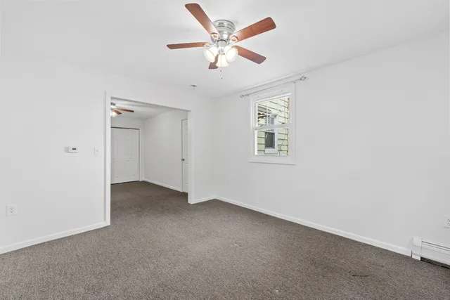 an empty room with closet and a ceiling fan