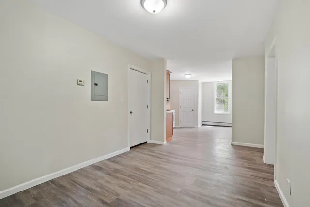 a view of an empty room with wooden floor