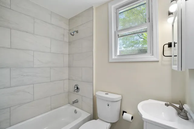 a bath room with a toilet sink bath tub and shower