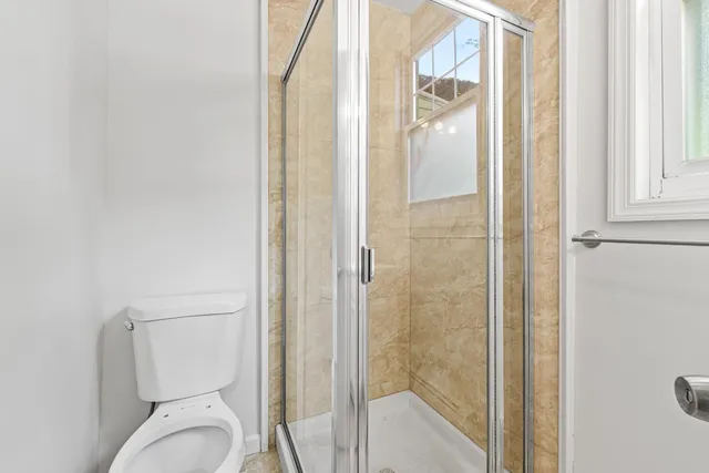 a bathroom with a toilet and a shower