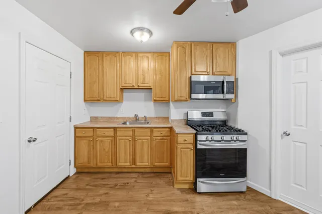 a kitchen with stainless steel appliances granite countertop a stove a sink and a microwave
