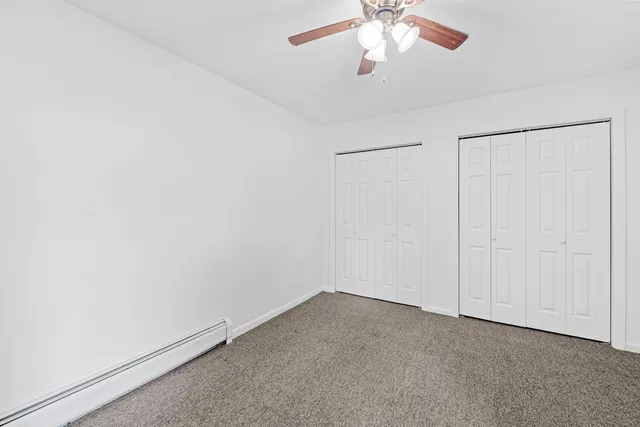 an empty room with a chandelier fan