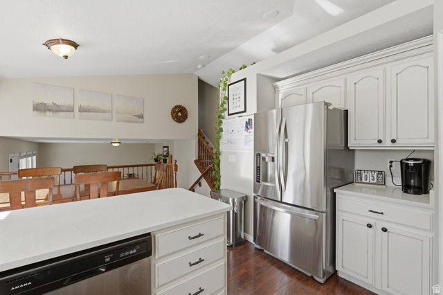 11189 Ohenry Road East Sandy, UT 84070 - Photo 10 of 44 Kitchen featuring a central island with a white countertop and integrated dishwasher, white cabinetry with dark hardware, stainless steel refrigerator, and wood-finish flooring