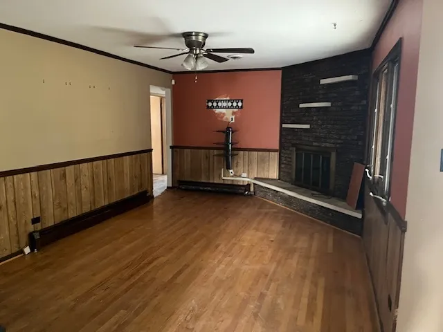 a view of a livingroom with wooden floor and a ceiling fan