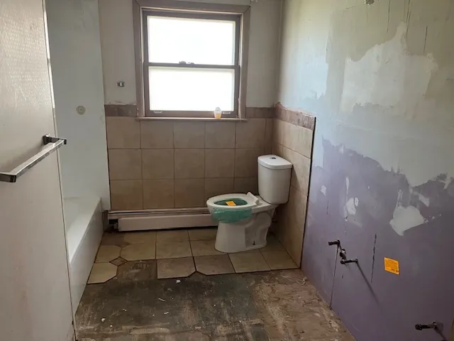 a bathroom with a toilet and a window