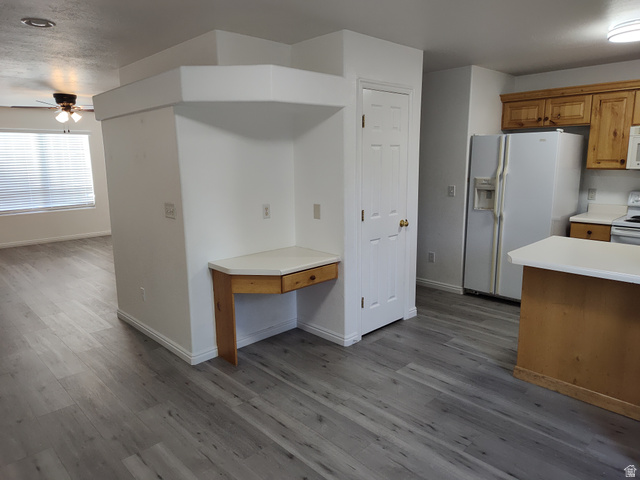 1735 West 540 North, Unit 1402 St. George, UT 84770 - Photo 6 of 14 Kitchen with white appliances, light countertops, brown cabinetry, and dark wood finished floors