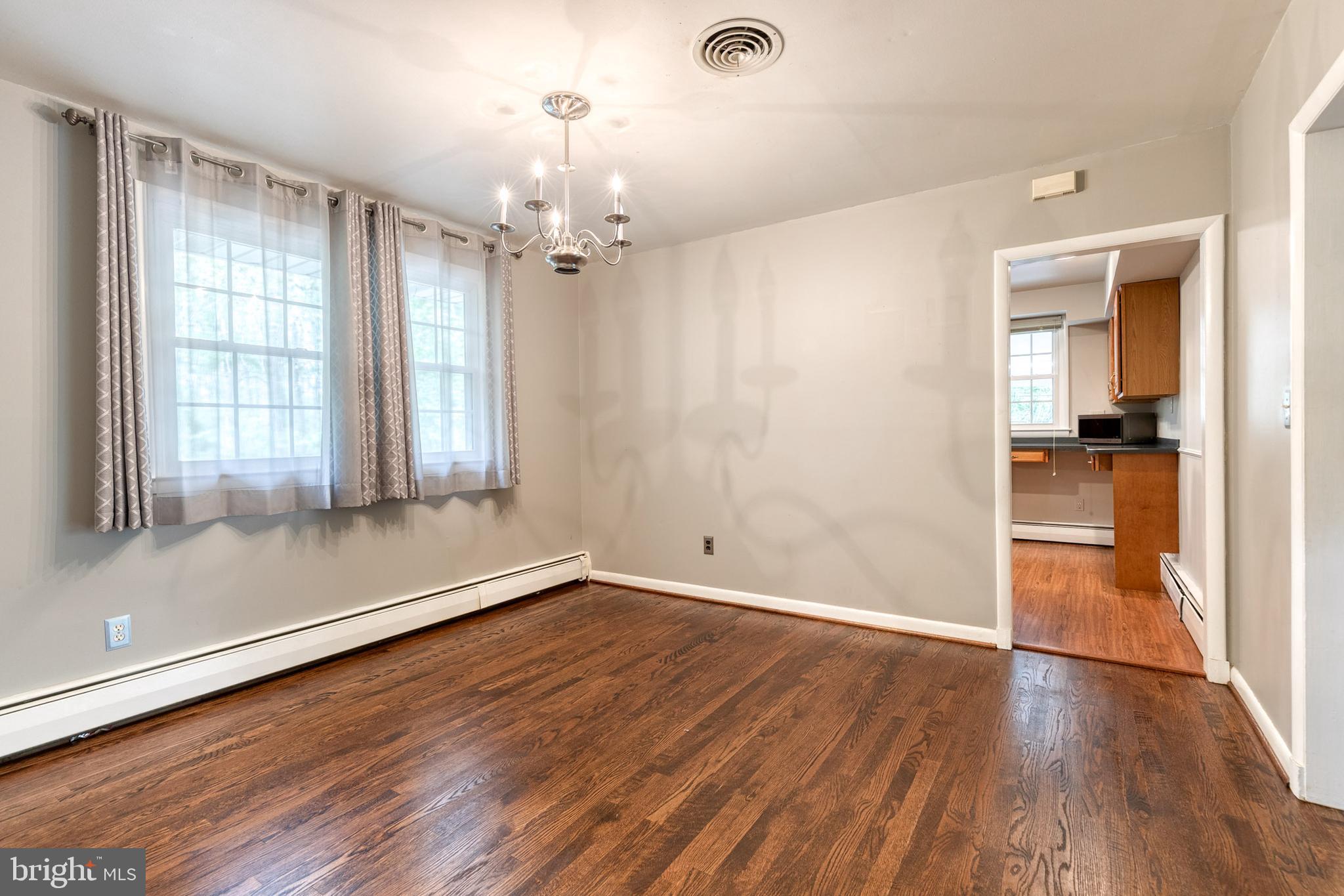 1022 Roxleigh Road Towson, MD 21286 - Photo 11 of 36 an empty room with wooden floor and windows
