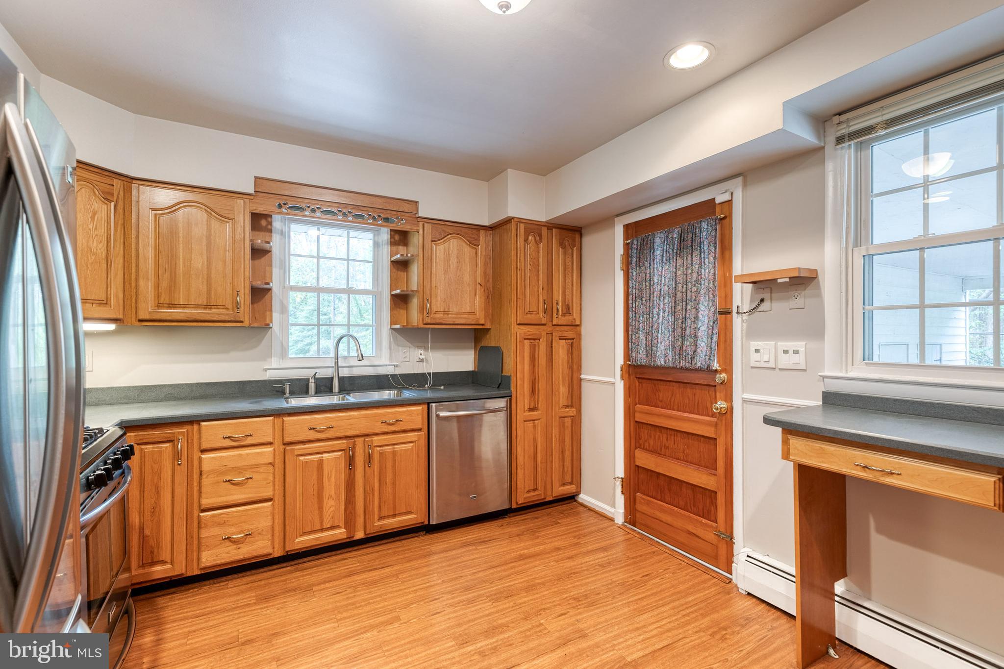 1022 Roxleigh Road Towson, MD 21286 - Photo 12 of 36 a kitchen with stainless steel appliances granite countertop a refrigerator and wooden cabinets