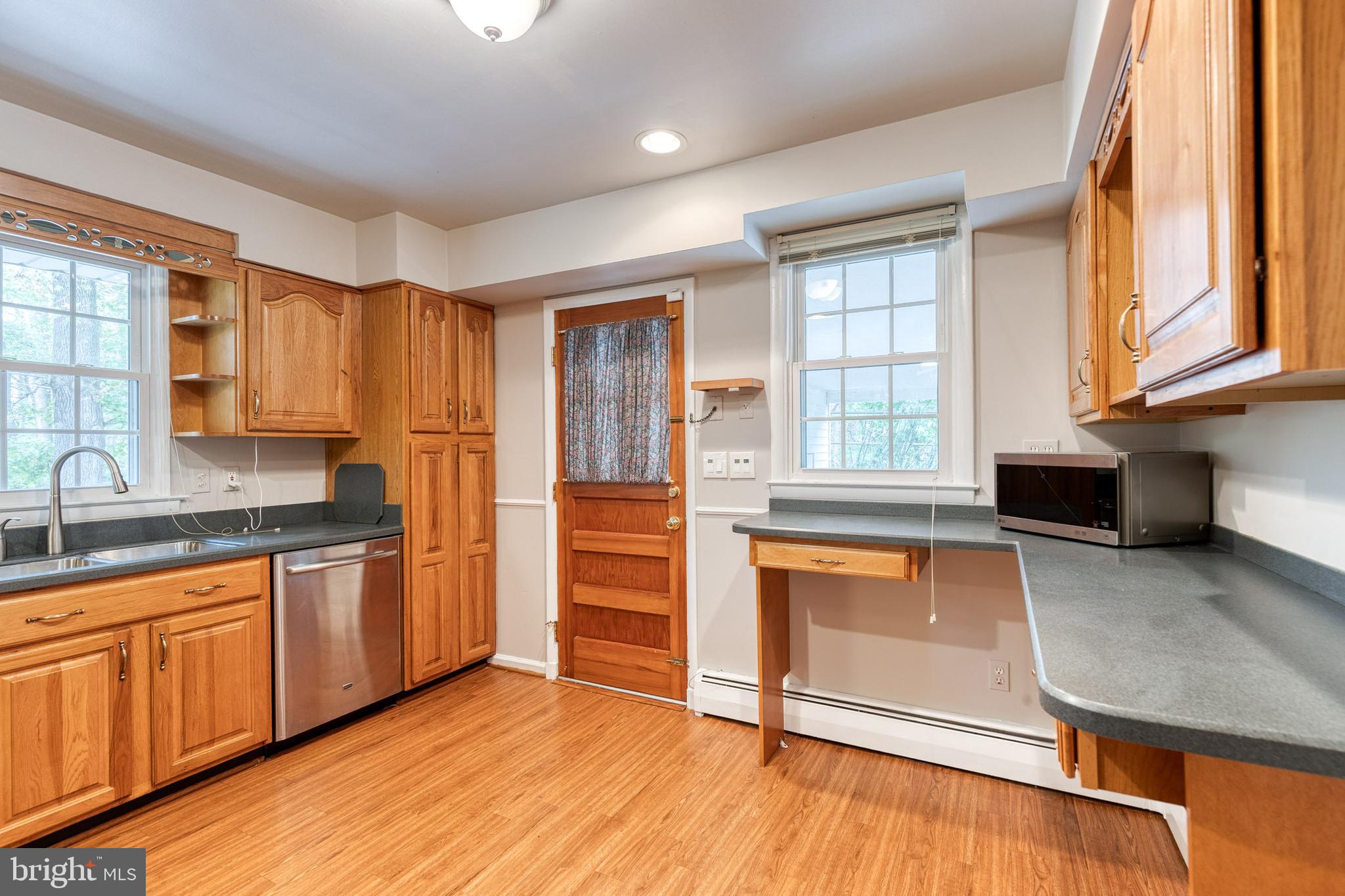 1022 Roxleigh Road Towson, MD 21286 - Photo 13 of 36 a kitchen with stainless steel appliances granite countertop a stove a sink and a refrigerator with wooden cabinets