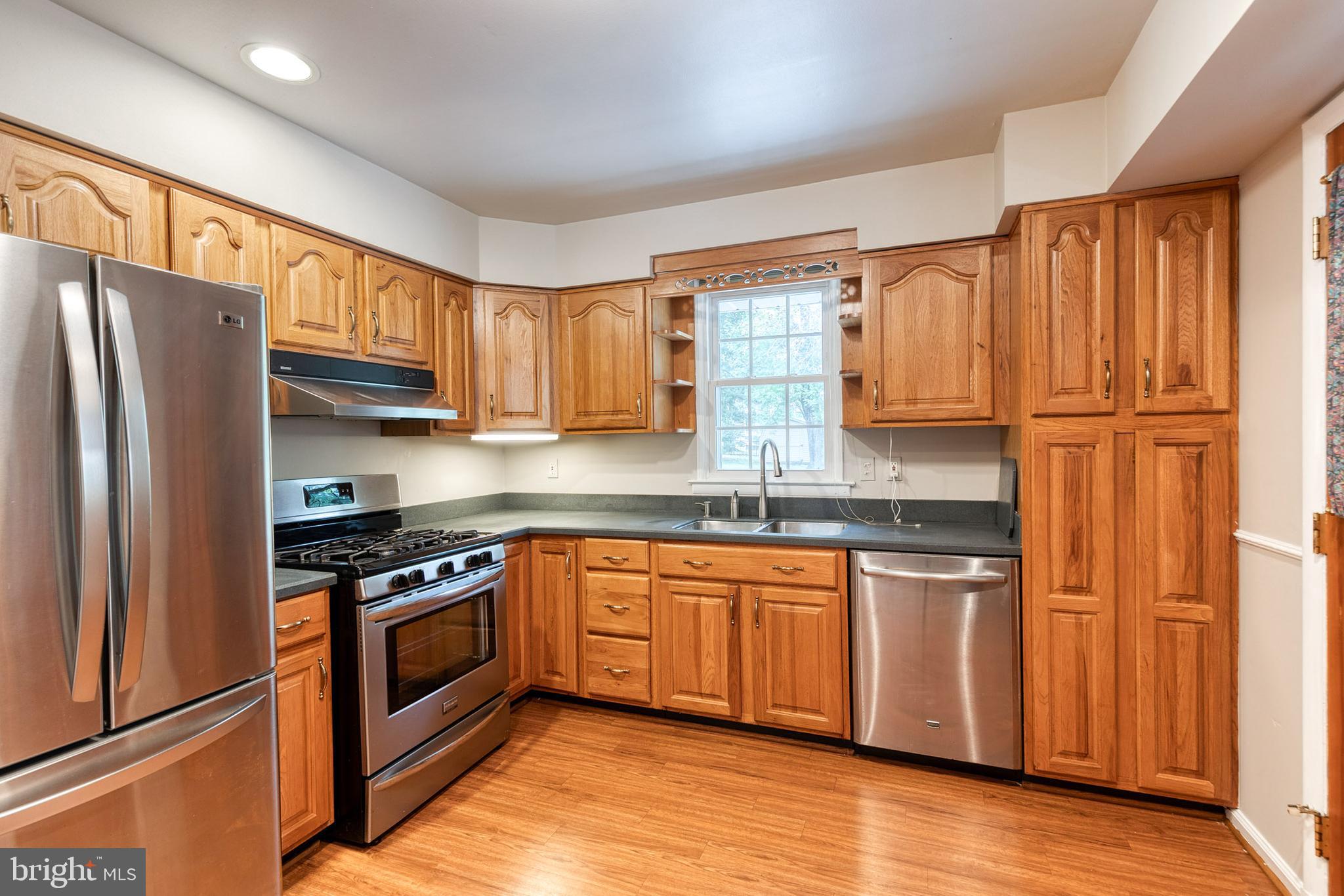 1022 Roxleigh Road Towson, MD 21286 - Photo 14 of 36 a kitchen with stainless steel appliances granite countertop a refrigerator sink and cabinets