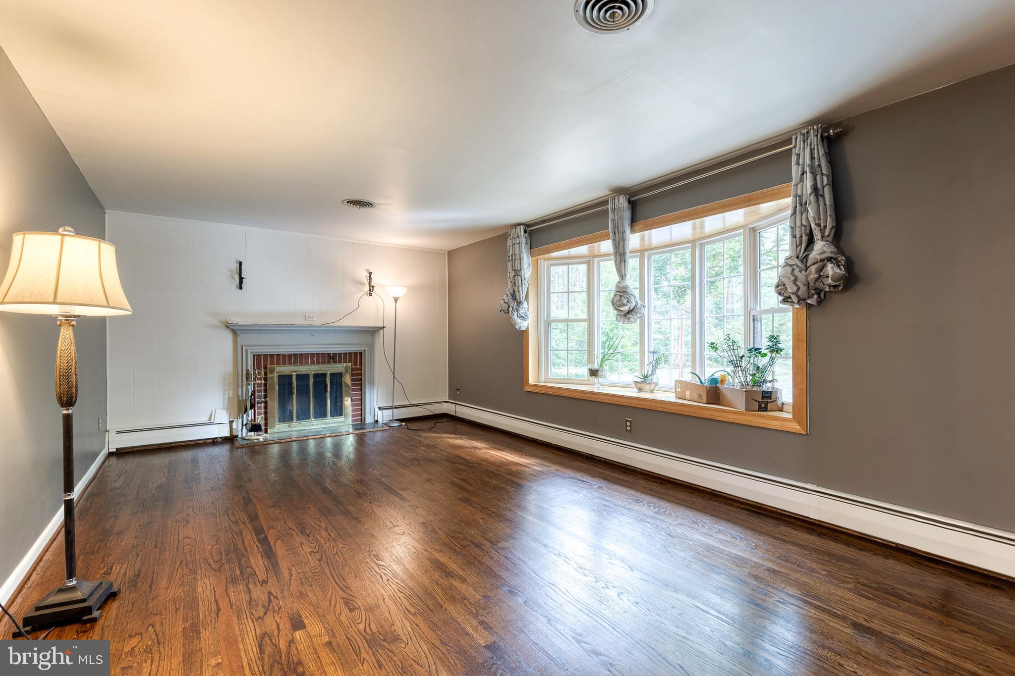 1022 Roxleigh Road Towson, MD 21286 - Photo 6 of 36 an empty room with wooden floor fireplace and windows