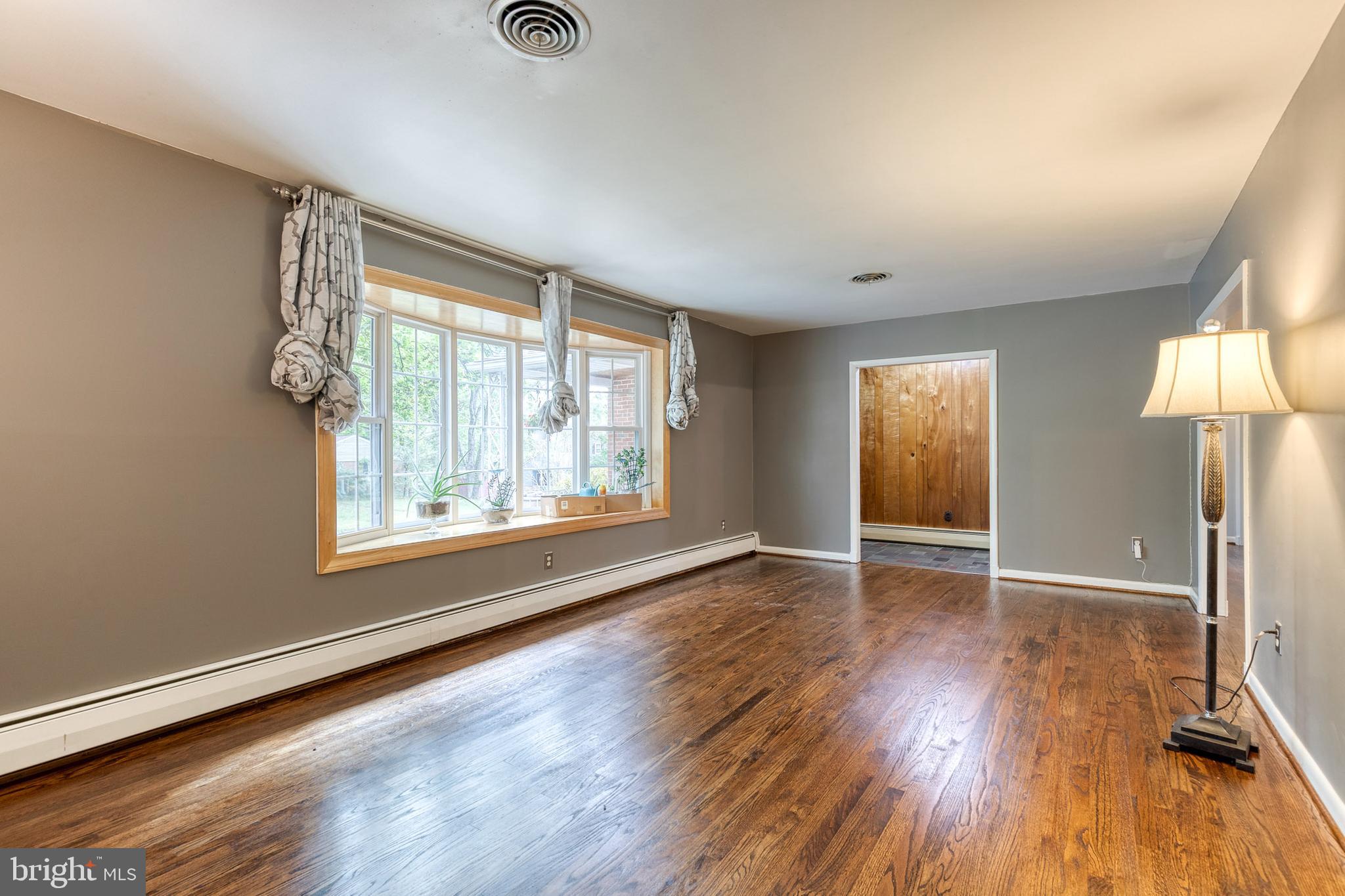 1022 Roxleigh Road Towson, MD 21286 - Photo 8 of 36 an empty room with wooden floor and windows