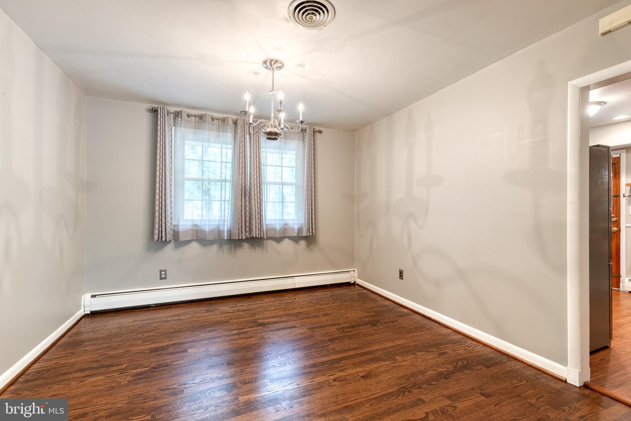 1022 Roxleigh Road Towson, MD 21286 - Photo 10 of 36 an empty room with wooden floor and windows