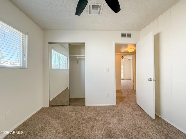 an empty room with closet and windows