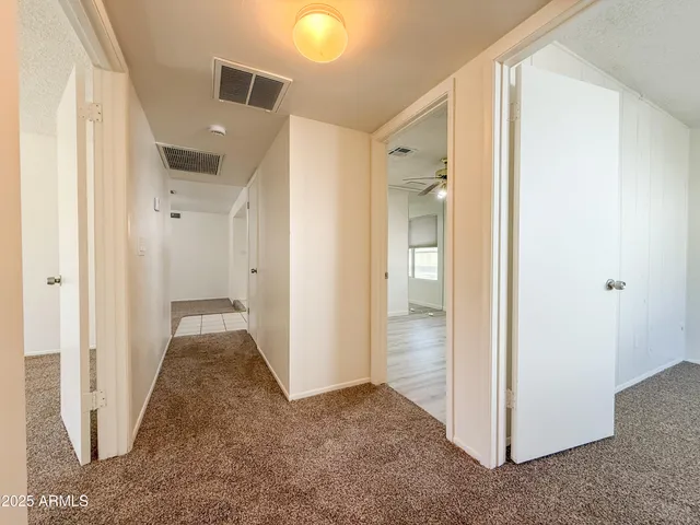 a view of a hallway with closet and wooden floor