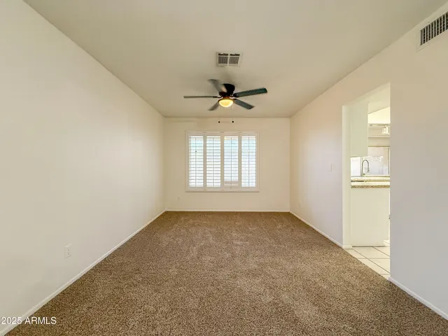 an empty room with a window and a ceiling fan