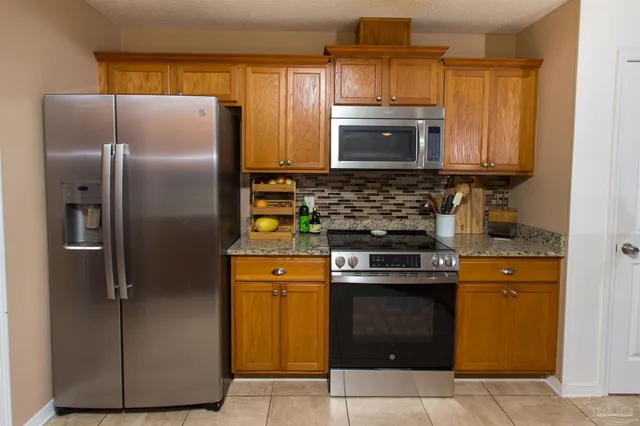 a kitchen with stainless steel appliances granite countertop a refrigerator and a stove