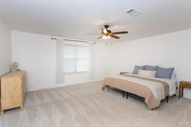 a spacious bedroom with a bed and a chandelier