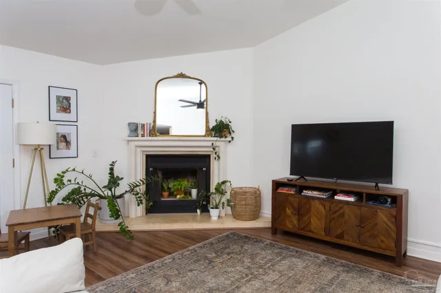 a living room with furniture a flat screen tv and a fireplace