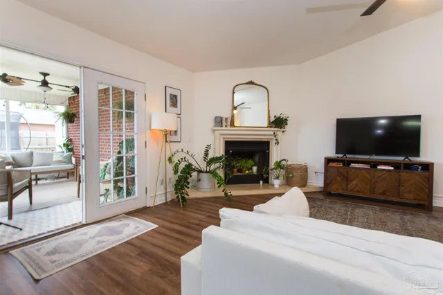 a living room with furniture a flat screen tv and a fireplace