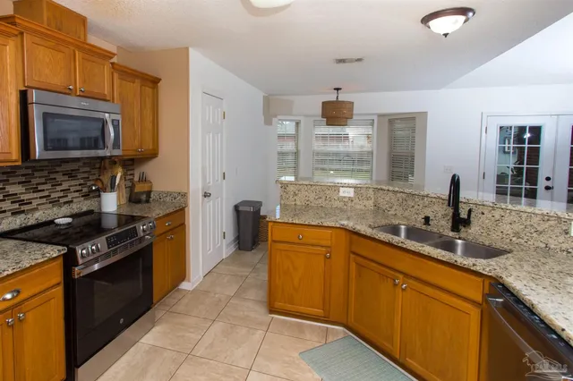a kitchen with stainless steel appliances granite countertop a sink stove and refrigerator