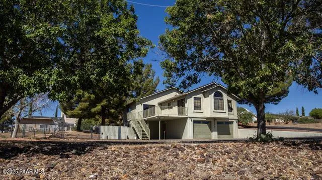 a white house that has a tree in front of it