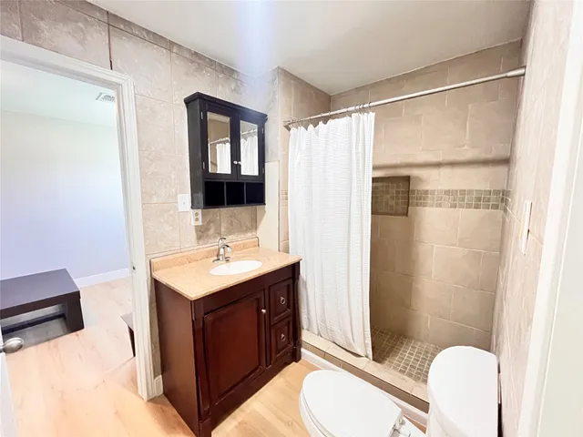 a bathroom with a sink toilet a mirror and shower