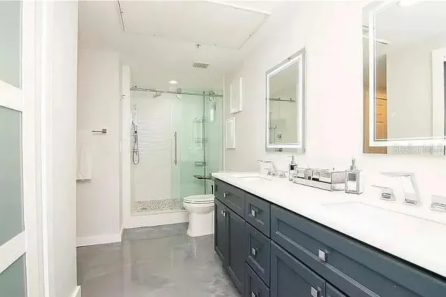 a bathroom with a sink a toilet and shower