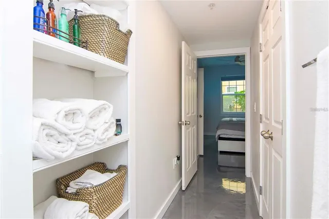 a hallway with white doors wooden floor and a living room