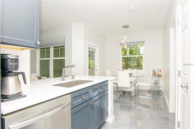 a dining hall with stainless steel appliances granite countertop a sink and dishwasher next to a window