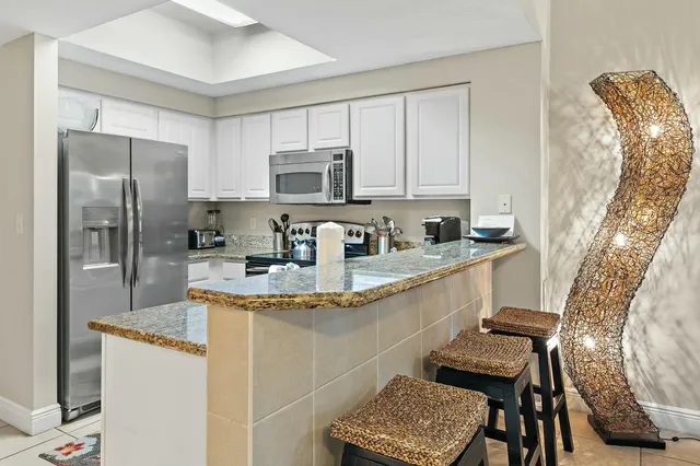 a kitchen with stainless steel appliances granite countertop a sink refrigerator and microwave