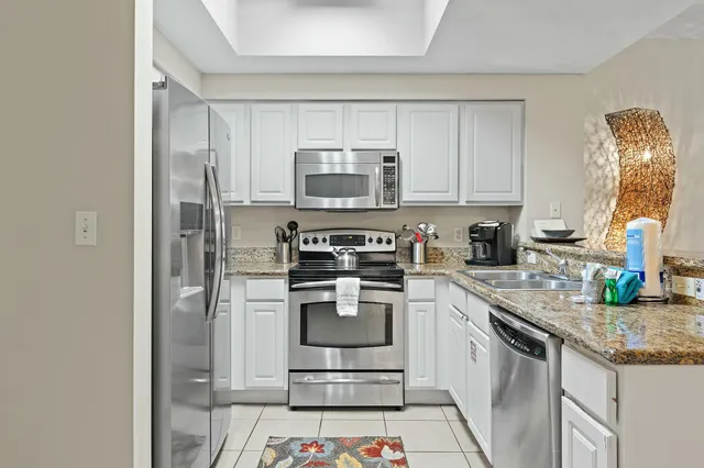 a kitchen with stainless steel appliances granite countertop a stove a sink and a refrigerator