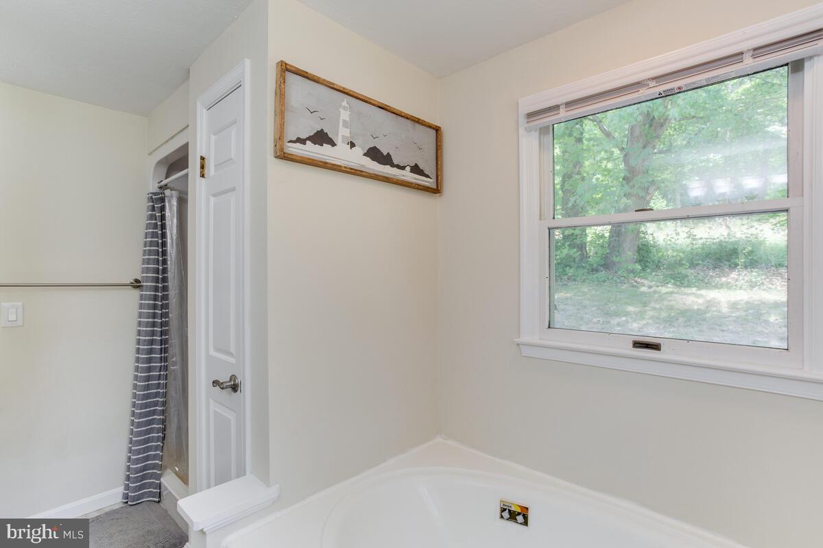 1260 Coster Road Lusby, MD 20657 - Photo 34 of 46 a bathroom with a window a bed and a window