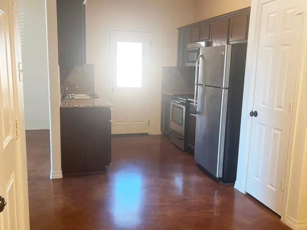 a view of a refrigerator in kitchen and wooden floor