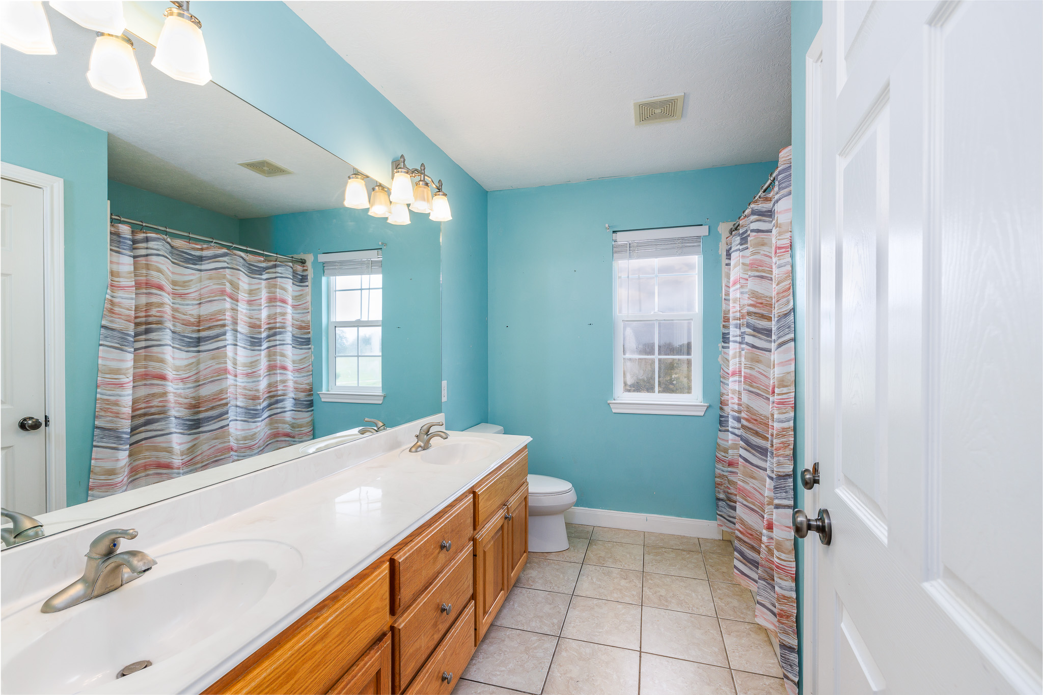 1710 Harwood Road Luling, TX 78648 - Photo 29 of 30 A long double vanity highlights this bathroom alongside classic tile flooring.