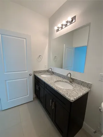 a bathroom with a granite countertop sink a toilet and shower