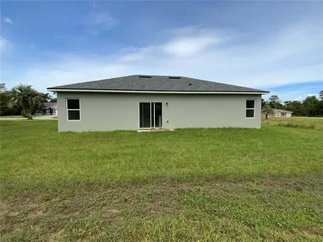 a backyard of a house with table and chairs