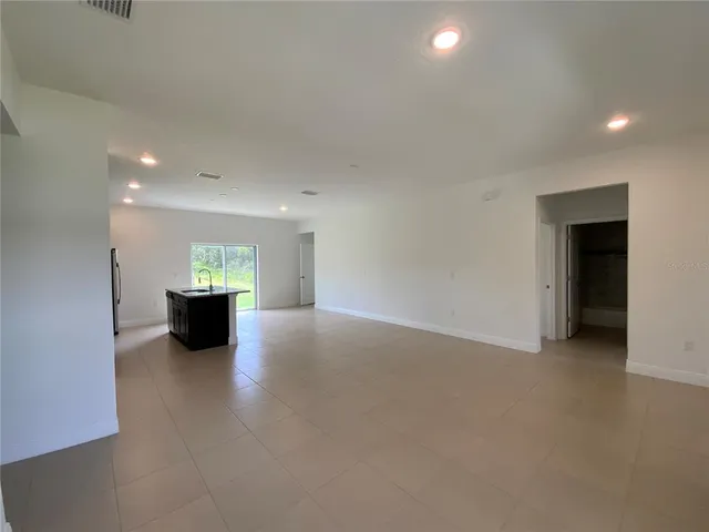 a view of an empty room with a kitchen