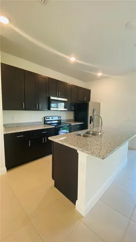 a kitchen with stainless steel appliances granite countertop a stove a sink and a refrigerator