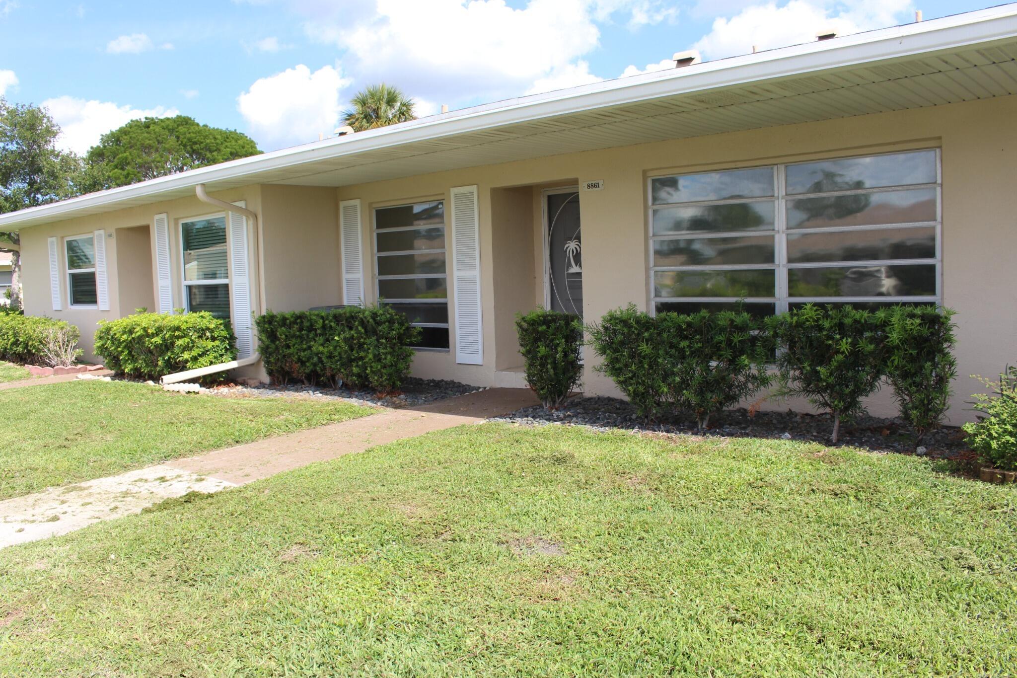 8861 Bella Vista Drive Boca Raton, FL 33433 - Photo 2 of 16 a front view of a house with garden