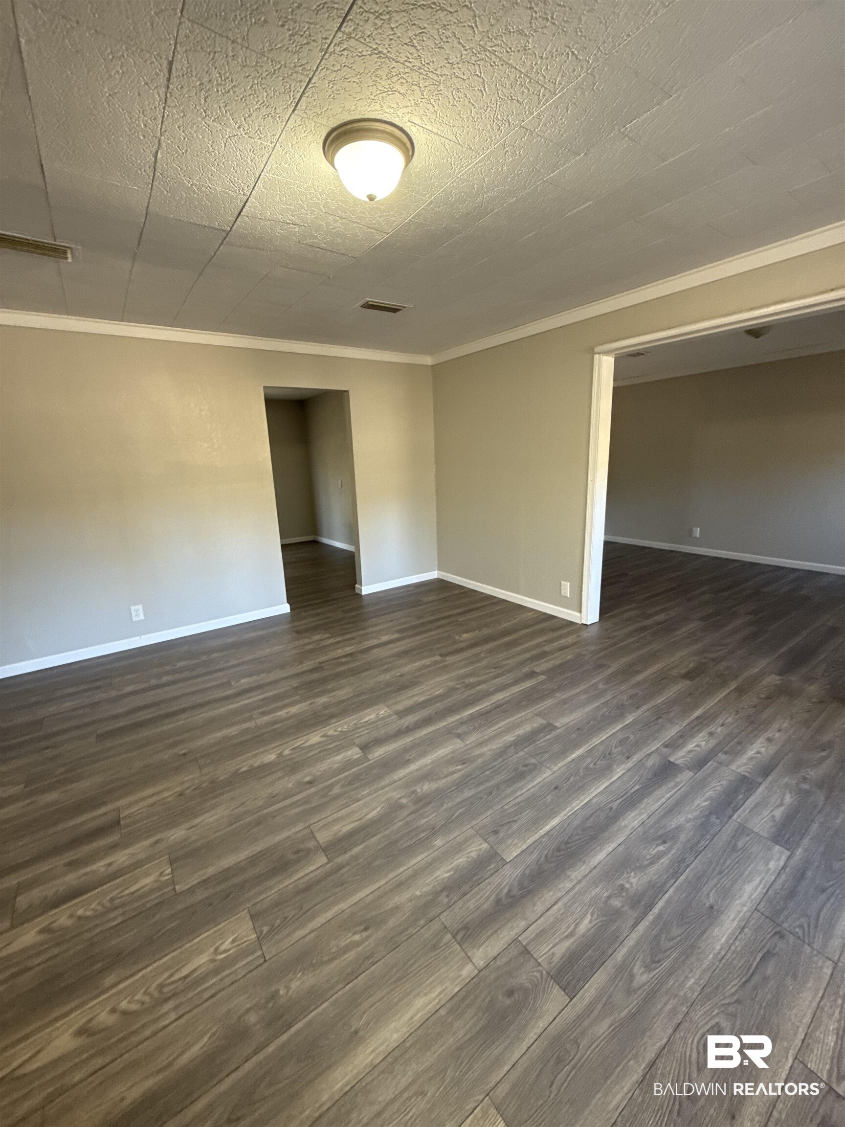 32 Slate Street Atmore, AL 36502 - Photo 3 of 16 Unfurnished room featuring dark wood-type flooring and crown molding