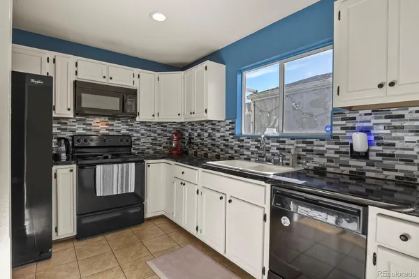 a kitchen with stainless steel appliances kitchen island granite countertop a refrigerator stove and sink