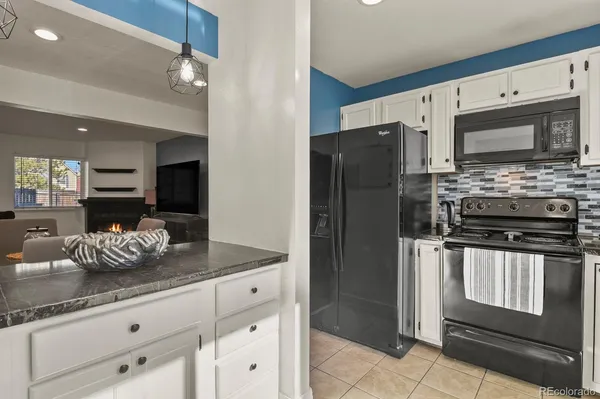a kitchen with granite countertop a sink a stove and cabinets