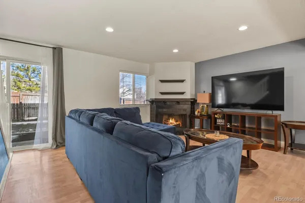 a living room with furniture a flat screen tv and a fireplace