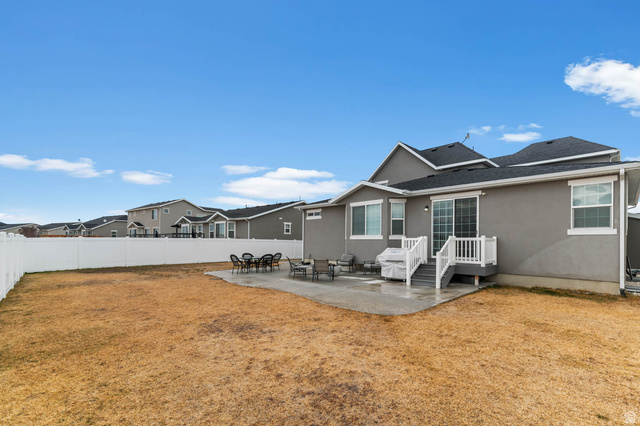 5686 Duke Lane Tooele, UT 84074 - Photo 6 of 38 Back of property with a patio area, a fenced backyard, and stucco siding