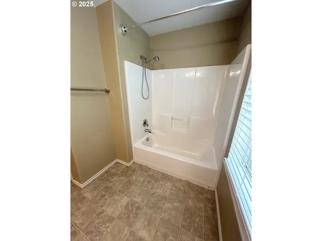 a bathroom with a bathtub and shower