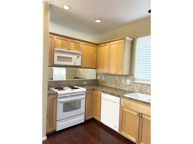 a kitchen with a stove a sink and white cabinets