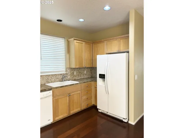 a kitchen with a refrigerator sink and cabinets