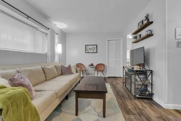 a living room with furniture a flat screen tv and a table